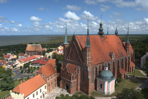 Widok z tarasu Wieży Radziejsowskiego. Na pierwszym planie katedra NMP i biblioteka muzealna, w tle Frombork i Zalew Wiślany 